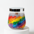 Clear glass cookie jar candle with rainbow paint-splatter interior and rainbow sparkle glitter wax top